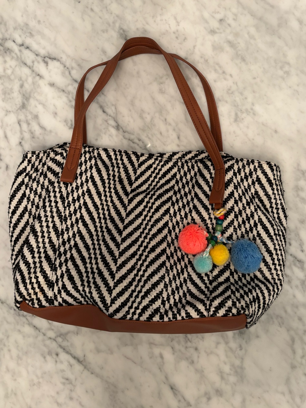 Black and white fabric purse with pompom tassels and lots of room and pockets